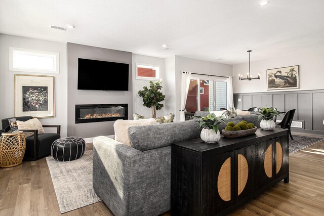 14236 Phoenix Pl, Holland, MI 49424 - living area with a chandelier, wood finished floors, a glass covered fireplace, and recessed lighting