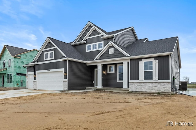 craftsman-style home featuring cooling unit and a garage