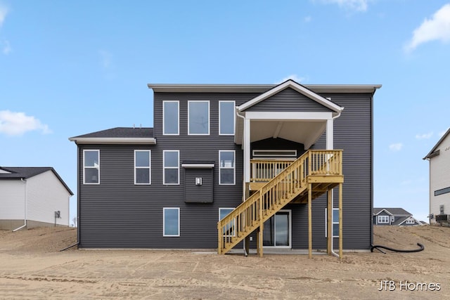 rear view of property featuring stairway and a wooden deck