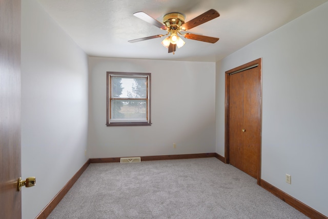 carpeted spare room with ceiling fan