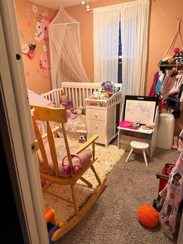 bedroom featuring carpet flooring and a nursery area