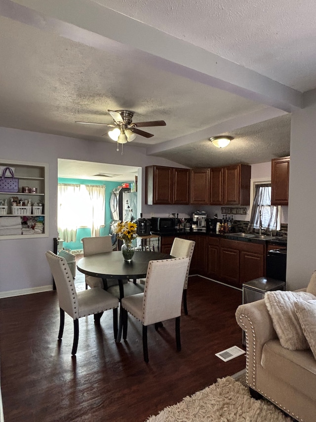 dining room featuring dark wood-style floors, visible vents, ceiling fan, and a textured ceiling