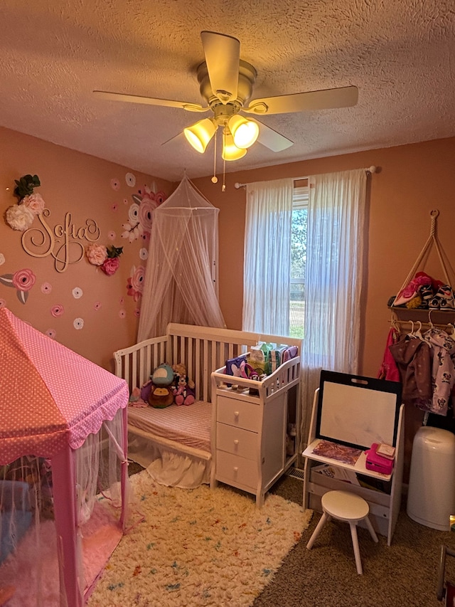 carpeted bedroom with a ceiling fan and a textured ceiling