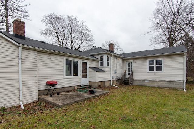 back of property with a yard and a patio