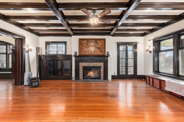 unfurnished living room featuring ceiling fan, hardwood / wood-style floors, beamed ceiling, and coffered ceiling