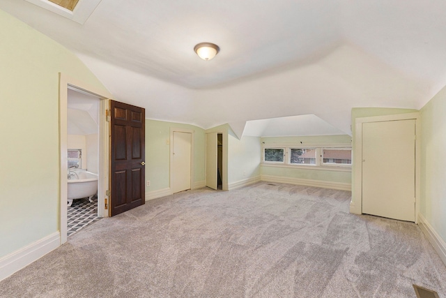 additional living space with light colored carpet and lofted ceiling