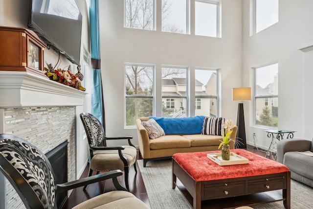 living room featuring a fireplace and a high ceiling