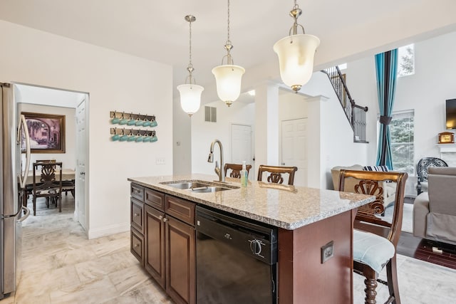 kitchen featuring sink, a center island with sink, black dishwasher, hanging light fixtures, and a breakfast bar area