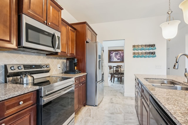 kitchen with backsplash, pendant lighting, sink, and stainless steel appliances