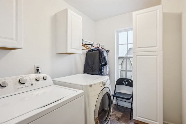 clothes washing area featuring cabinets and separate washer and dryer