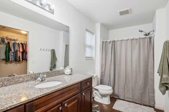 bathroom featuring walk in shower, hardwood / wood-style floors, vanity, and toilet