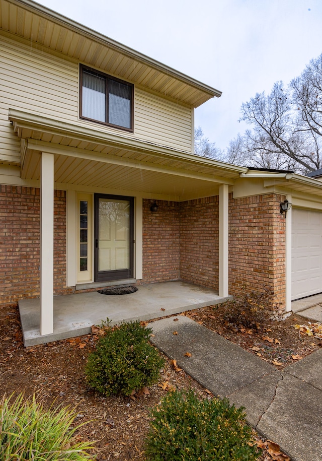 doorway to property featuring covered porch and a garage