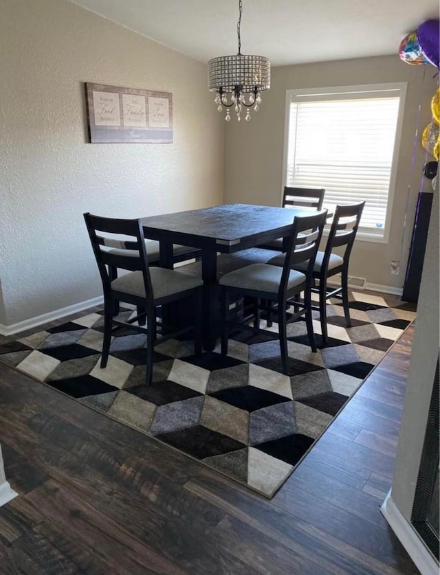 dining room featuring dark hardwood / wood-style flooring, lofted ceiling, and a notable chandelier