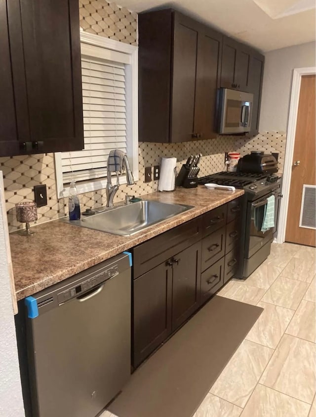 kitchen with sink, dishwashing machine, black gas range oven, and tasteful backsplash