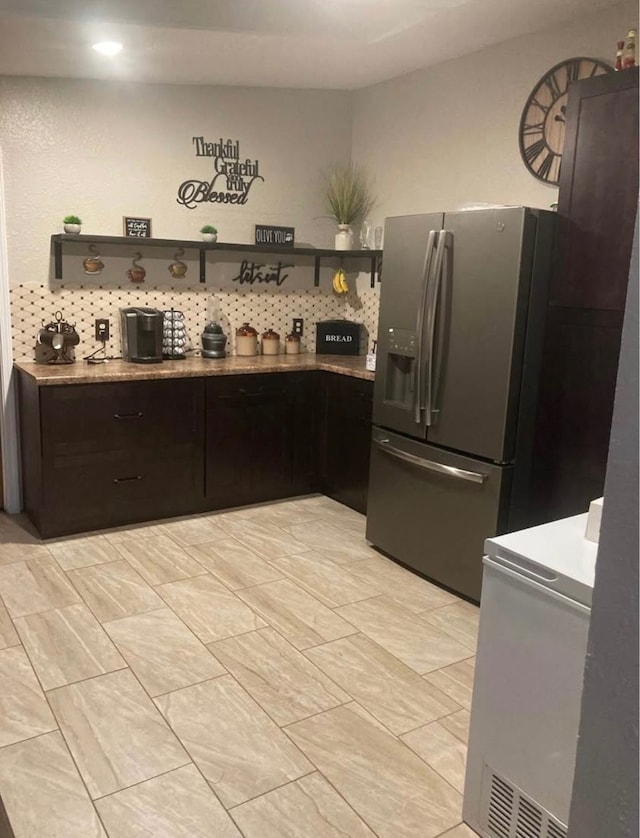 kitchen with backsplash and stainless steel refrigerator with ice dispenser