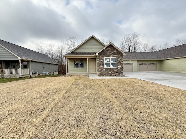 view of front facade featuring a garage, stone siding, and concrete driveway