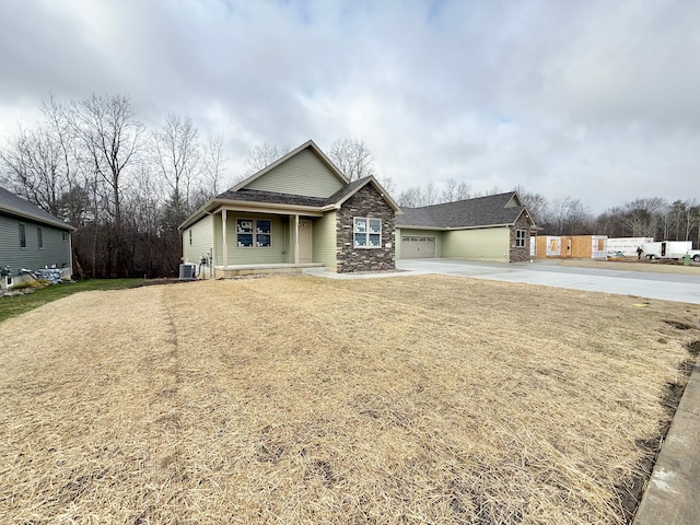 view of front of house featuring a front lawn, central AC unit, and a garage