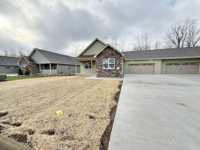 view of front of home featuring covered porch, central AC, and a garage