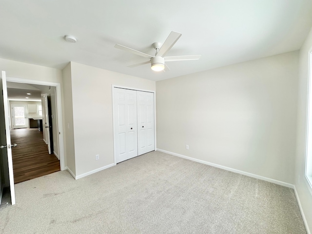 unfurnished bedroom featuring carpet, ceiling fan, and a closet