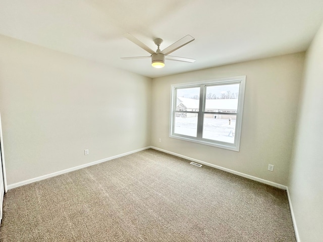 carpeted spare room featuring ceiling fan