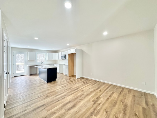 kitchen featuring white cabinets, a kitchen island, and light hardwood / wood-style floors