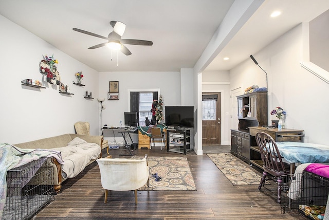 living room with dark hardwood / wood-style flooring and ceiling fan