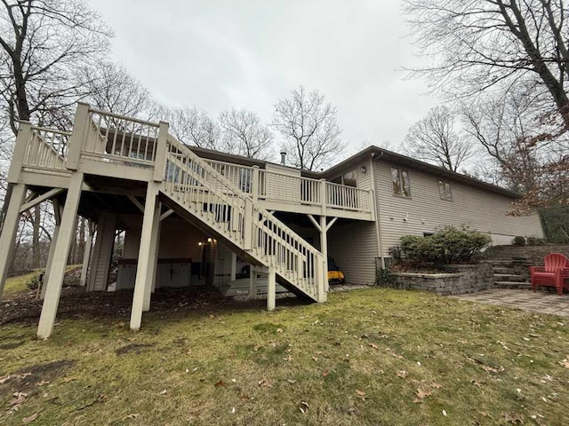 back of house with a lawn, a patio, and a wooden deck