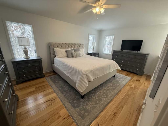 bedroom featuring multiple windows, light hardwood / wood-style flooring, and ceiling fan