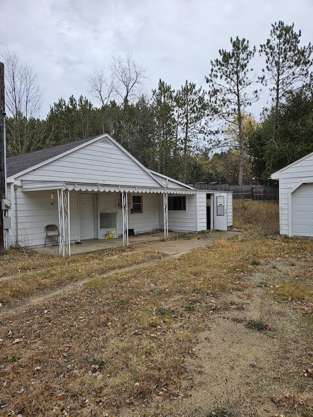 rear view of property featuring an outbuilding and a porch