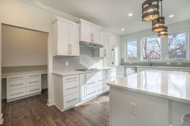 kitchen featuring light countertops, under cabinet range hood, stainless steel dishwasher, black electric cooktop, and tasteful backsplash