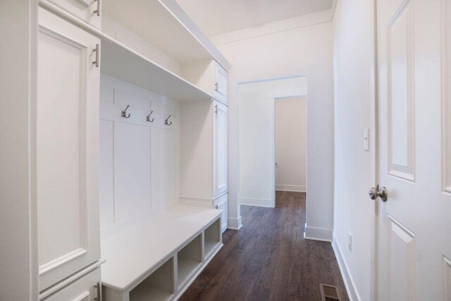 mudroom featuring visible vents, baseboards, and dark wood-style flooring