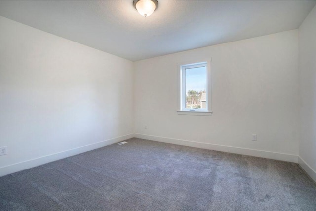 unfurnished room featuring baseboards and carpet