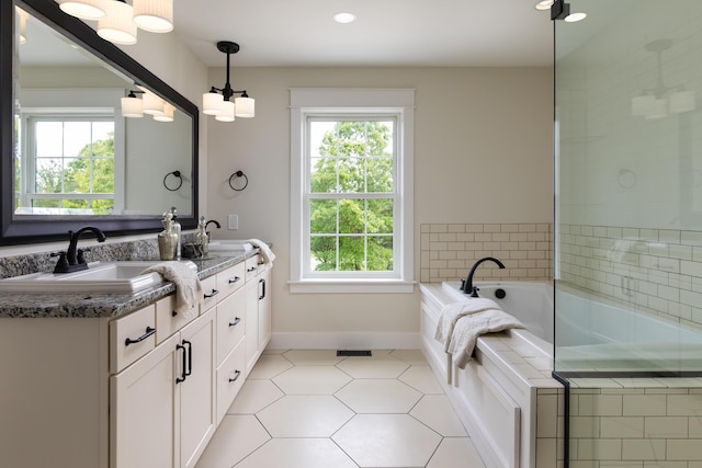 bathroom featuring a sink, a healthy amount of sunlight, a bath, and double vanity