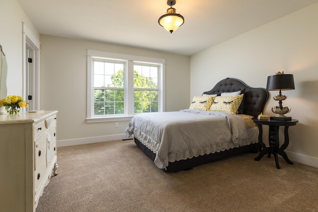 bedroom with baseboards and light carpet