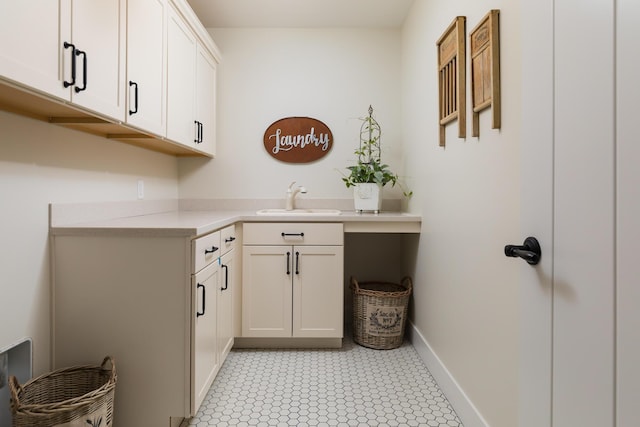 washroom featuring baseboards and a sink