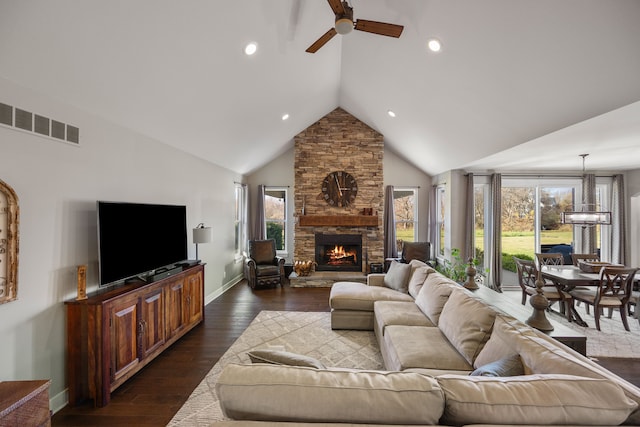 living room featuring ceiling fan with notable chandelier, high vaulted ceiling, a fireplace, and dark hardwood / wood-style flooring