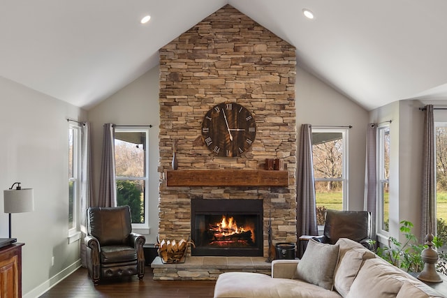 living room with a stone fireplace, dark hardwood / wood-style flooring, and high vaulted ceiling