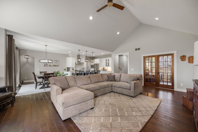 living room with french doors, ceiling fan with notable chandelier, high vaulted ceiling, and dark hardwood / wood-style flooring