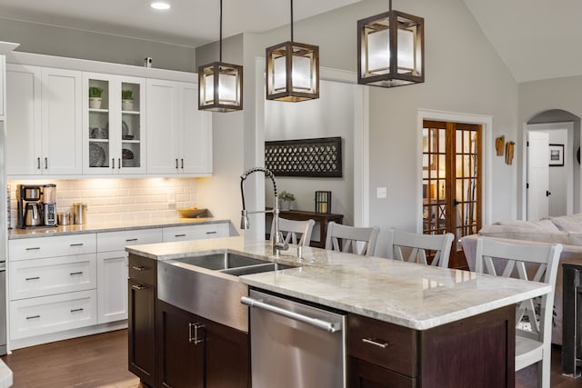 kitchen featuring dishwasher, decorative light fixtures, decorative backsplash, and a kitchen breakfast bar