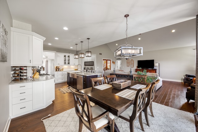 dining space with sink, dark hardwood / wood-style flooring, and lofted ceiling