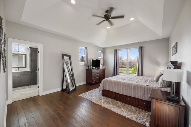 bedroom featuring ceiling fan, multiple windows, ensuite bath, and a tray ceiling