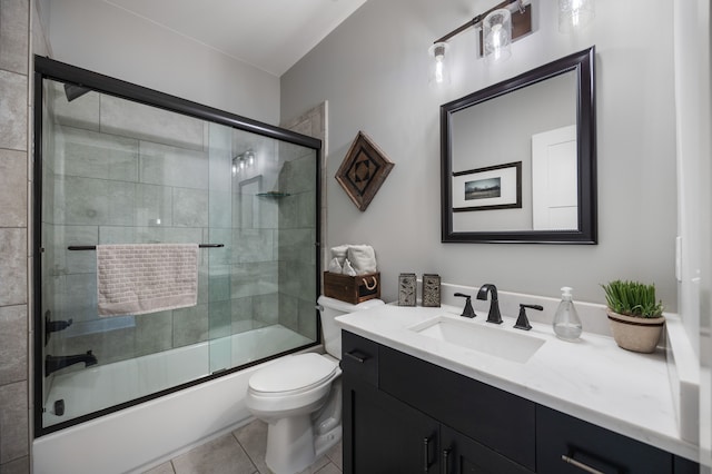 full bathroom with combined bath / shower with glass door, toilet, tile patterned floors, and vanity