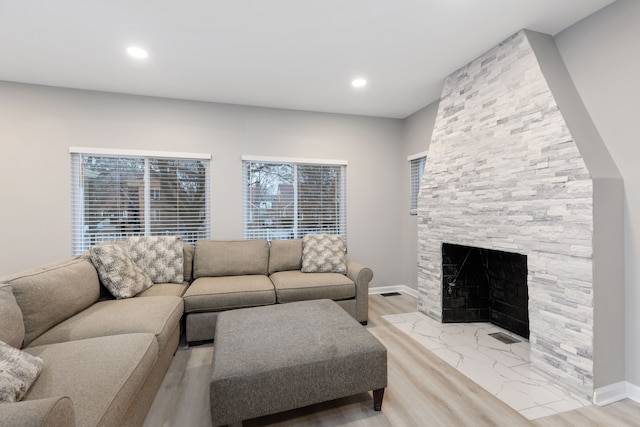 living room with a fireplace and light wood-type flooring