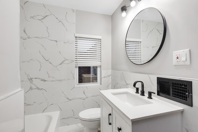 bathroom with vanity, a tub to relax in, toilet, and tile walls