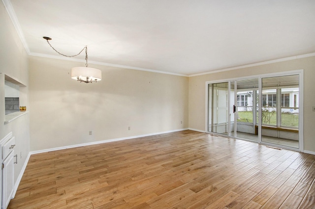 empty room featuring light hardwood / wood-style floors, crown molding, and a chandelier