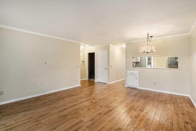 unfurnished living room featuring hardwood / wood-style floors, crown molding, and an inviting chandelier