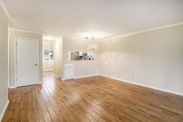 unfurnished living room featuring a chandelier, hardwood / wood-style flooring, and crown molding