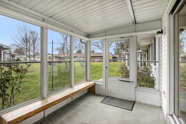 unfurnished sunroom featuring vaulted ceiling