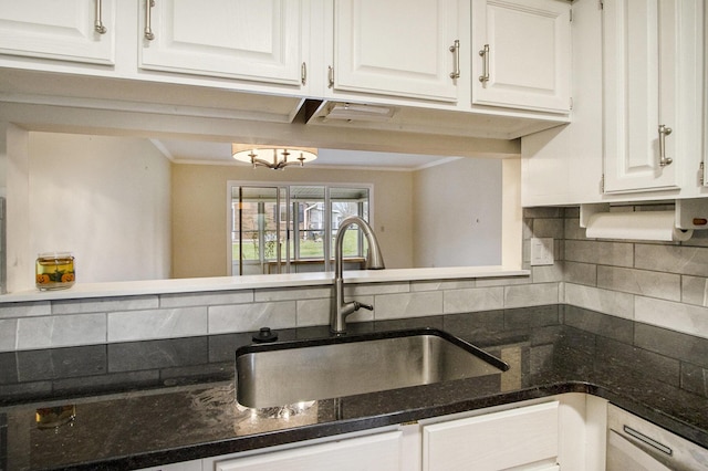 kitchen with dark stone countertops, white cabinetry, sink, and tasteful backsplash