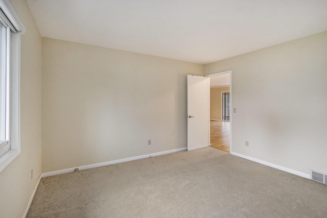 carpeted empty room with plenty of natural light